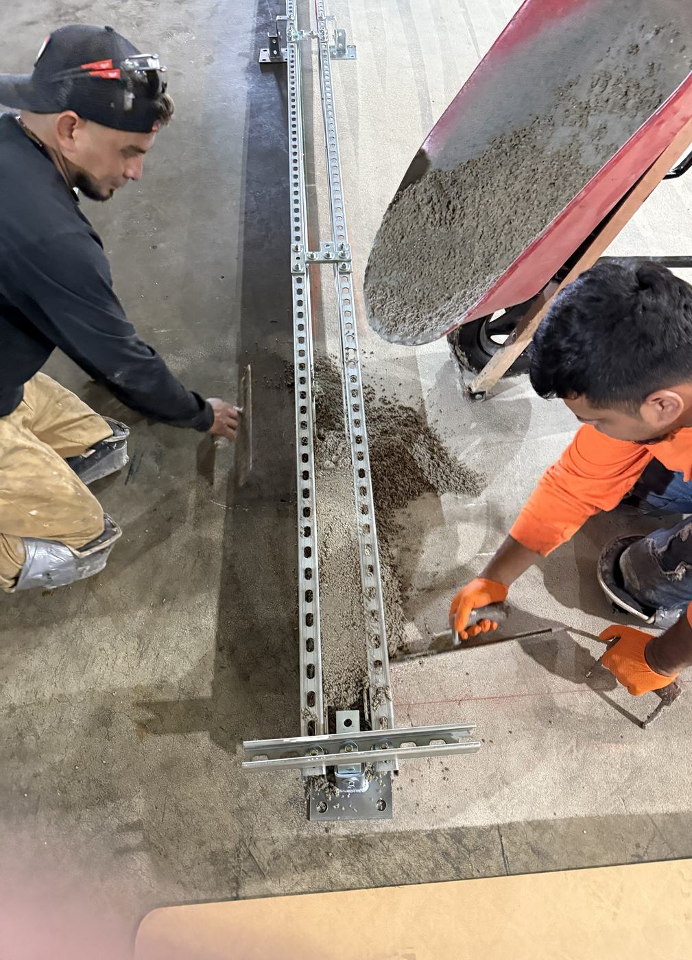 Installation crew placing the urethane containment curb inside the forms