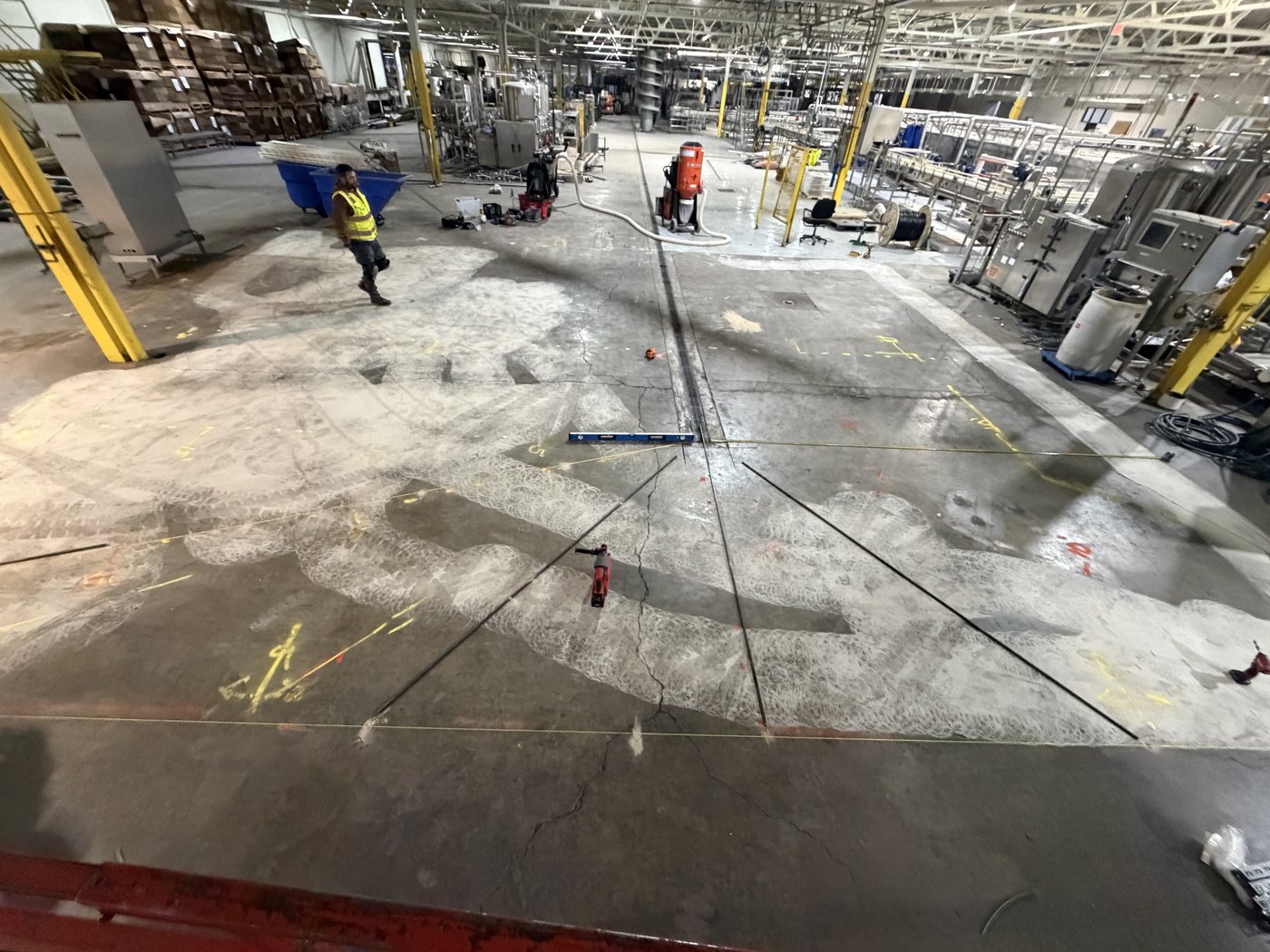 Crew mapping floor elevations and the curb line inside a bottling plant
