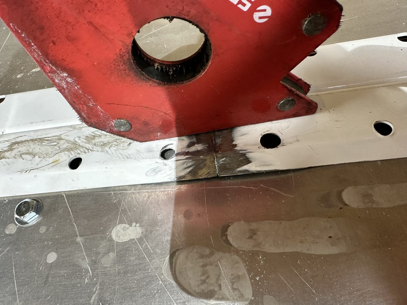 Welded 90-degree pivot bracket for the custom squeegee, on the fabrication bench