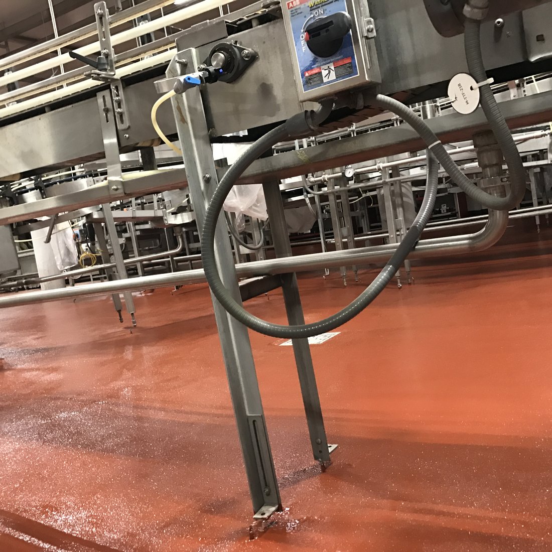 Beverage plant bottling line before and after: failed floor replaced with seamless urethane mortar