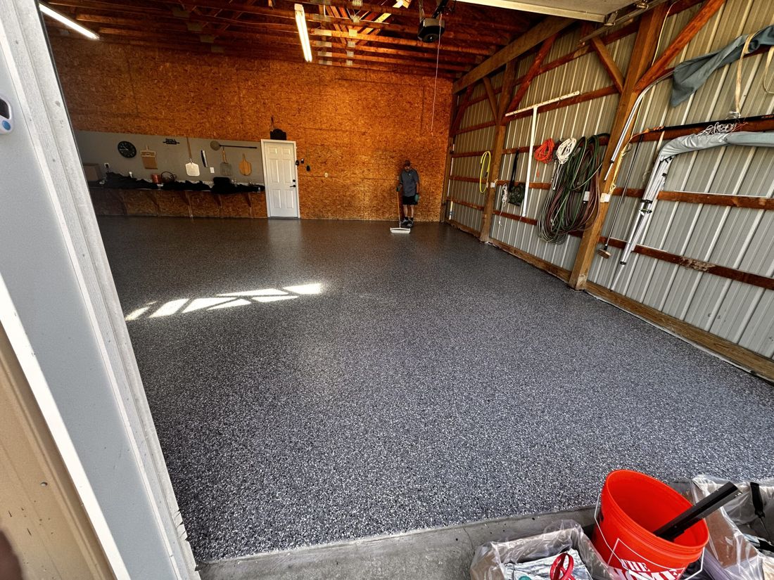 Rolling clear topcoat on MavTop UQB quartz broadcast floor, storage shed — during installation