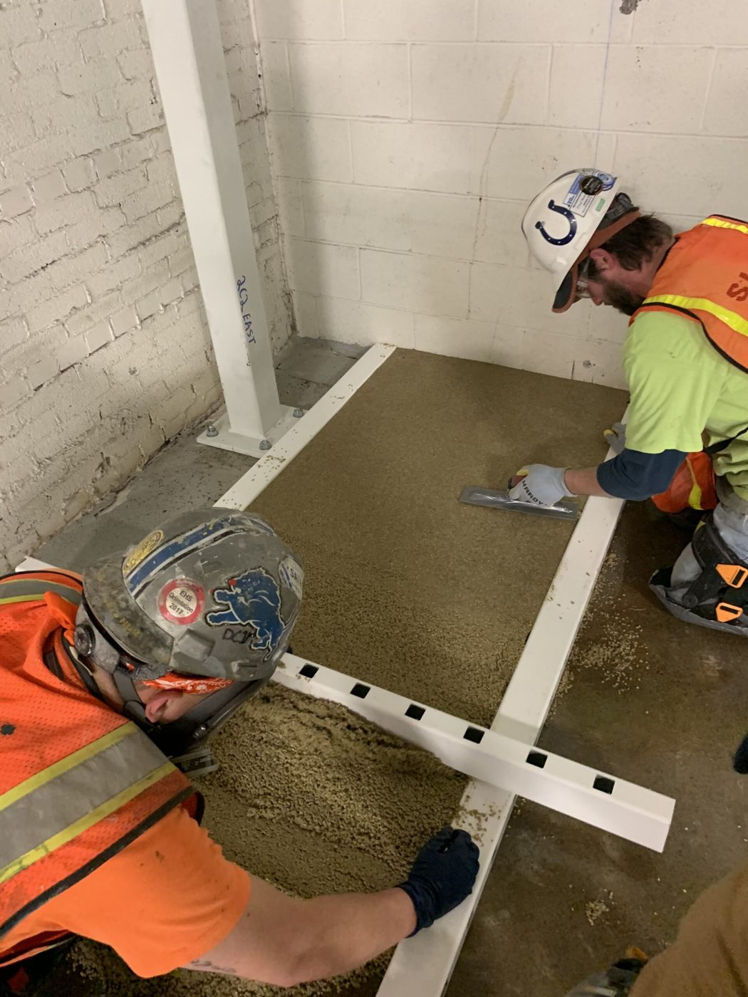Crew troweling MavPolyPatch resurfacing in plant equipment room — during installation