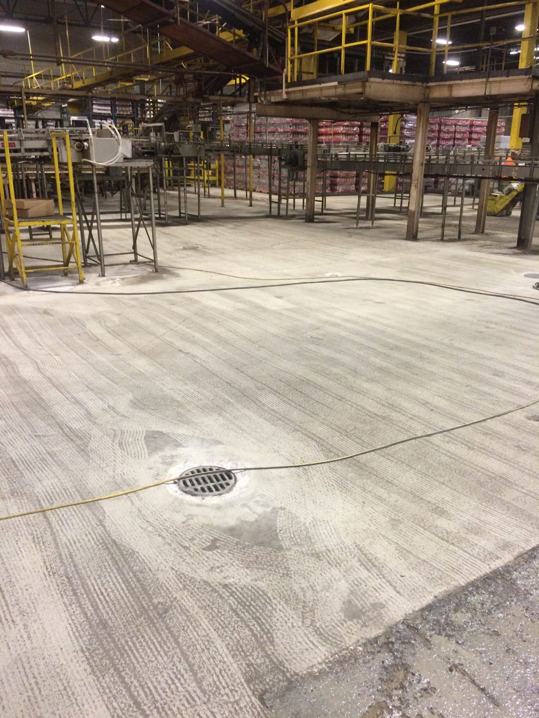 Prepped concrete and floor drain at beverage bottling plant, Detroit — before resurfacing
