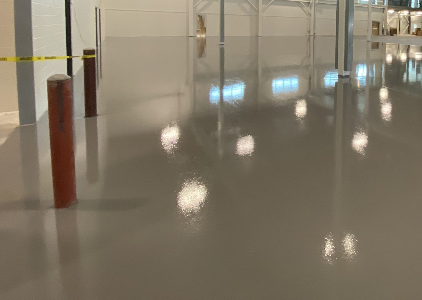 MavCoat SLE self-leveling epoxy, fresh pour across warehouse floor — during installation