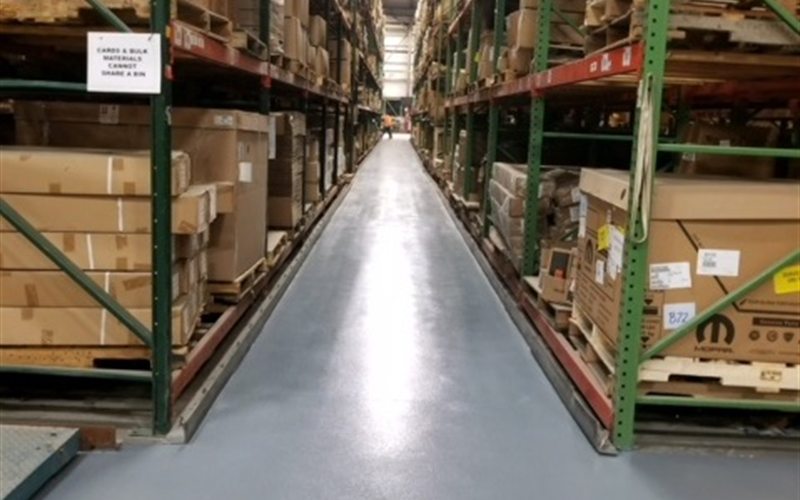 Distribution warehouse aisle with a MavCoat PC prime-and-coat broadcast floor between pallet racking
